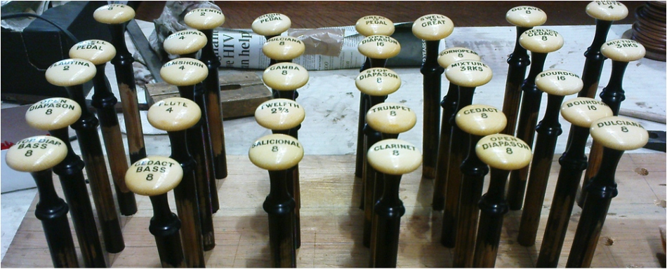 an array of pipe organ stop knobs